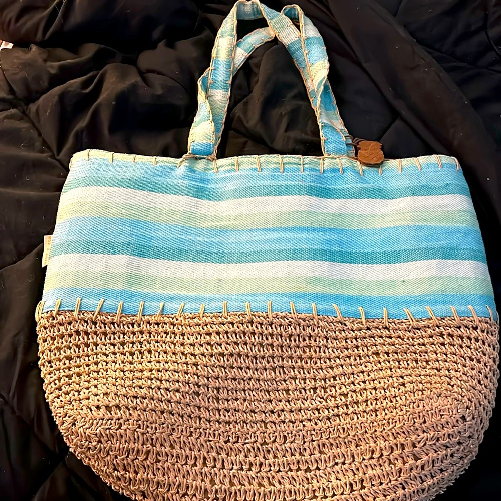 Woven tan and blue beach bag with inside pockets.